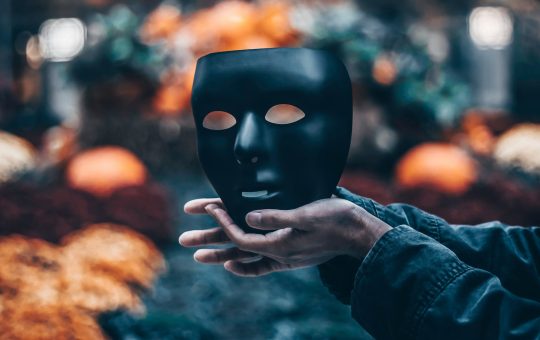 Person holding a mask following an AI sector study highlighting that record growth is masking serious challenges including skills, safety, infrastructure, security, and more, according to the authors of the report.